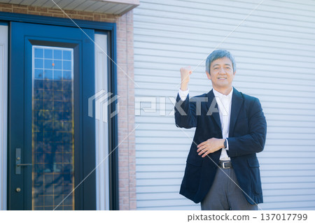 A man in his 60s thinking in front of the company building A man in his 60s thinking in front of the company building 137017799