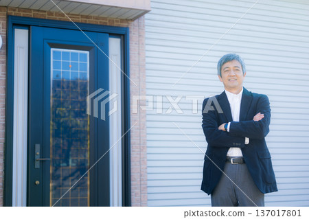 A man in his 60s thinking in front of the company building A man in his 60s thinking in front of the company building 137017801