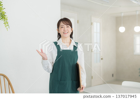A woman with a smile wearing an apron 137017945