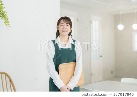 A woman with a smile wearing an apron A woman with a smile wearing an apron 137017946