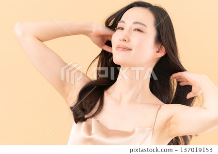 一位女士在米色背景下進行護膚的美麗圖片 137019153