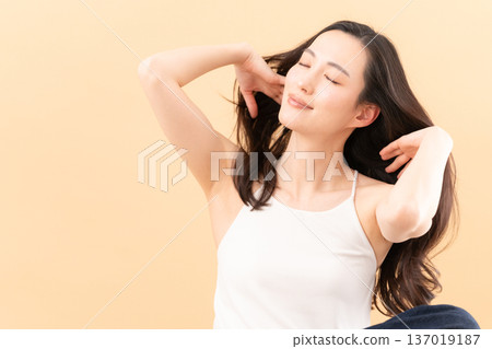 Beauty image of a woman doing skin care on a beige background 137019187