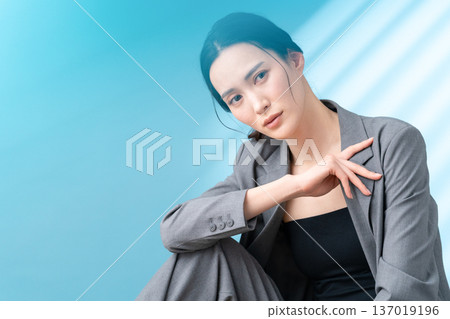 Beauty image of a woman doing skin care on a blue background 137019196