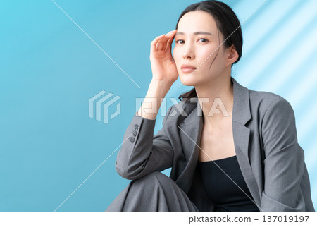 Beauty image of a woman doing skin care on a blue background 137019197