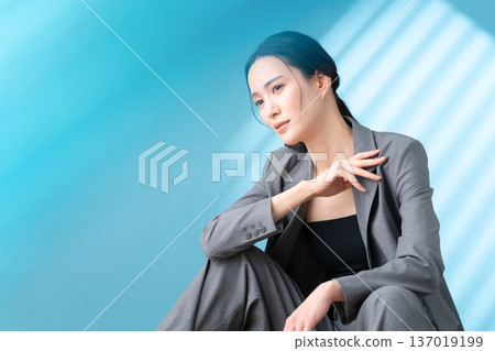 在藍色背景下，一位女士正在進行護膚的美麗圖片 137019199