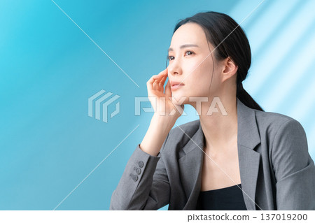 Beauty image of a woman doing skin care on a blue background 137019200