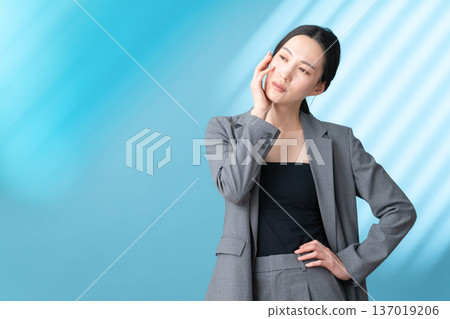 在藍色背景下，一位女士正在進行護膚的美麗圖片 137019206
