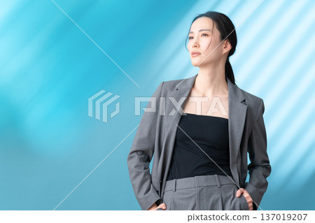 在藍色背景下，一位女士正在進行護膚的美麗圖片 137019207