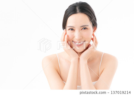 白色背景下，一位女士正在進行護膚的美麗圖片 137019214