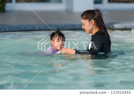 preschool child girl playing and swimming with her mother in pool preschool child girl playing and swimming with her mother in pool 137019393