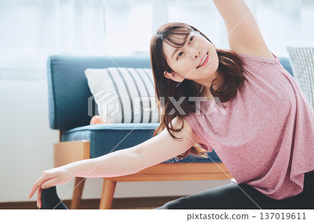 Healthy habits of a woman in her 30s stretching at home Healthy habits of a woman in her 30s stretching at home 137019611