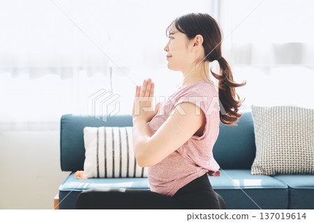 Fitness life of a woman in her 30s doing yoga poses in her living room 137019614