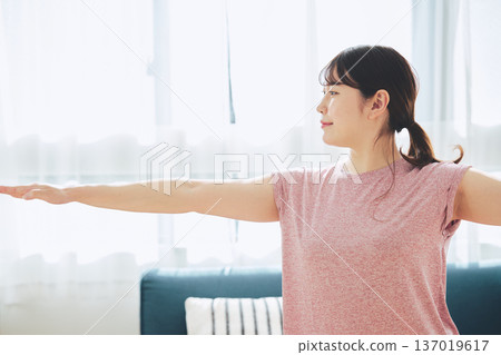 Fitness life of a woman in her 30s doing yoga poses in her living room 137019617