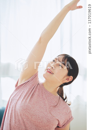 Healthy habits of a woman in her 30s stretching at home 137019619