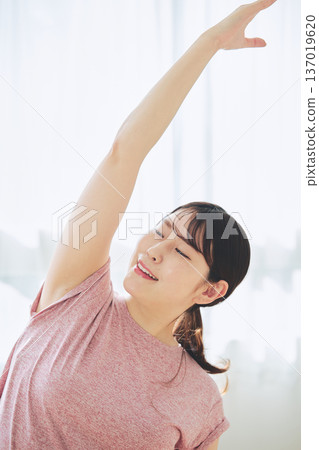 Healthy habits of a woman in her 30s stretching at home 137019620