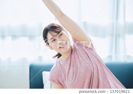 Healthy habits of a woman in her 30s stretching at home 137019621