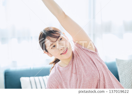 Healthy habits of a woman in her 30s stretching at home 137019622