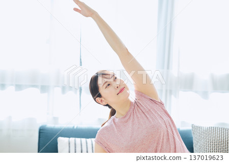 Healthy habits of a woman in her 30s stretching at home 137019623