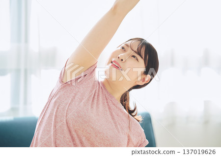 Healthy habits of a woman in her 30s stretching at home Healthy habits of a woman in her 30s stretching at home 137019626