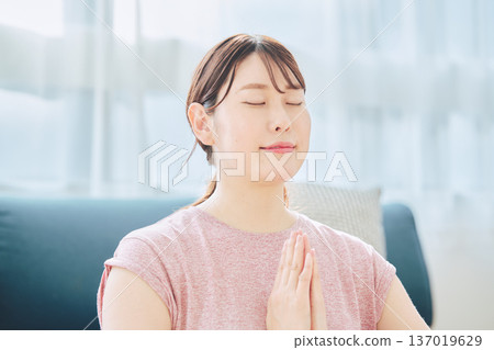 一位30多歲的女性在家中進行冥想和深呼吸,實踐正念生活方式。 一位30多歲的女性在家中進行冥想和深呼吸,實踐正念生活方式。 137019629