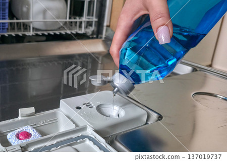 Loading the dishwasher. Tablets and rinse aid to start the dishwasher cycle. High quality photo 137019737