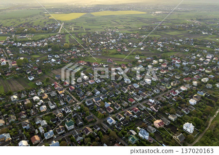 Aerial landscape of small town or village with rows of residential homes and green trees. 137020163