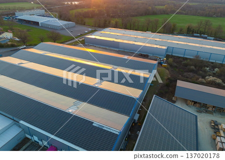 Aerial view of blue photovoltaic solar panels mounted on industrial building roof for producing green ecological electricity. Production of sustainable energy concept 137020178