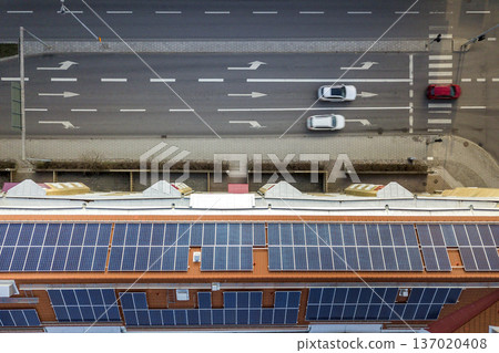 Aerial view of solar photo voltaic panels system on apartment building roof. Renewable ecological green energy production concept. 137020408