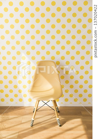 A yellow chair in front of a cute yellow dotted wall A yellow chair in front of a cute yellow dotted wall 137020422