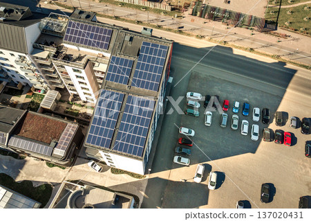Aerial view of solar photovoltaic panels on a roof top of residential building block for producing clean electric energy. Autonomous housing concept. 137020431