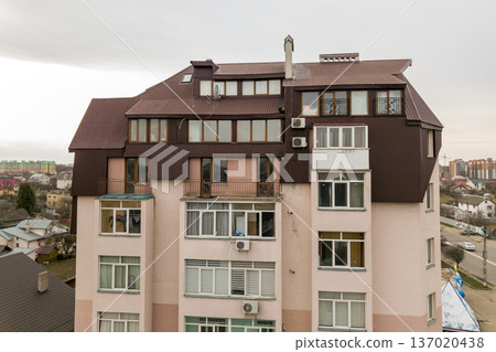 High apartment building with many windows and metal sheets roof. High apartment building with many windows and metal sheets roof. 137020438