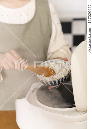 Hands pouring freshly cooked rice into bowls 137020462