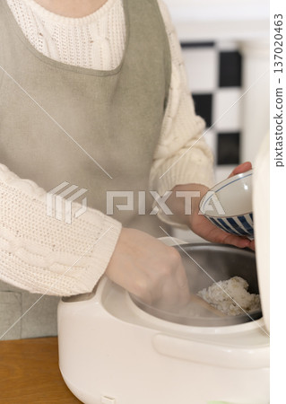 Hands pouring freshly cooked rice into bowls Hands pouring freshly cooked rice into bowls 137020463