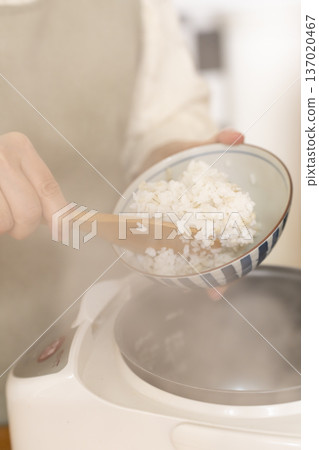 雙手將剛煮好的米盛入碗中 雙手將剛煮好的米盛入碗中 137020467