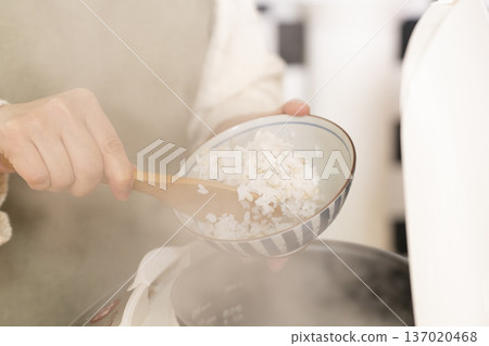 Hands pouring freshly cooked rice into bowls 137020468