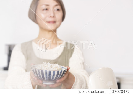 雙手將剛煮好的米盛入碗中 雙手將剛煮好的米盛入碗中 137020472