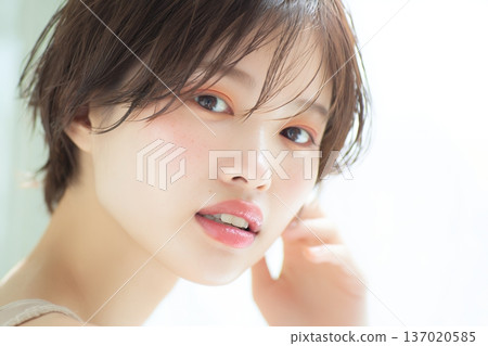 一張女性肖像照，她笑容清澈自然，周圍環繞著柔和的光線（橫幅照片）。 137020585
