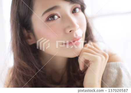 一張女性肖像照，她笑容清澈自然，周圍環繞著柔和的光線（橫幅照片）。 137020587