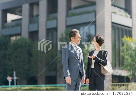 Men and women in suits standing in an office district Men and women in suits standing in an office district 137021584