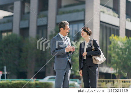 Men and women in suits standing in an office district Men and women in suits standing in an office district 137021589