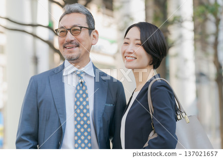 Men and women in suits standing on a street corner Men and women in suits standing on a street corner 137021657