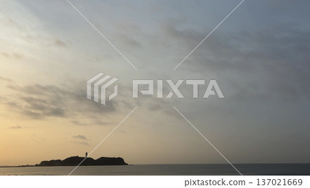 平靜的海面，晨曦初露，一座島嶼上矗立著燈塔。 137021669