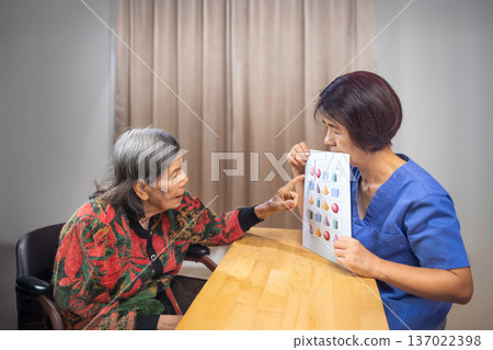 Asian Elderly Woman with Dementia Practicing match pictures. 137022398
