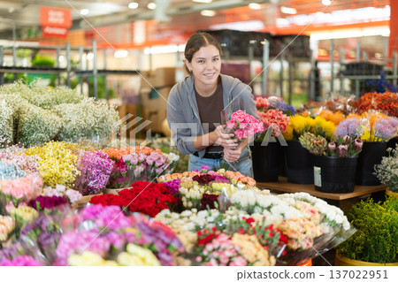 Female customer chooses a bouquet of carnations in flower shop Female customer chooses a bouquet of carnations in flower shop 137022951