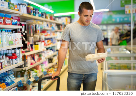Man choosing frozen food in supermarket 137023330