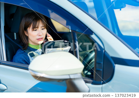 A woman talking on a smartphone in a car A woman talking on a smartphone in a car 137023419