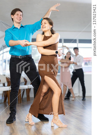 Young couples learning to dance latin american dances in dance studio 137023421