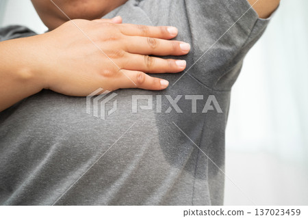 Sweaty underarms, Asian woman with sweat on clothes under armpit. Sweaty underarms, Asian woman with sweat on clothes under armpit. 137023459
