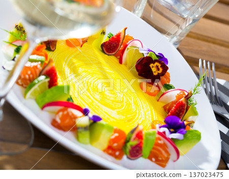 Tartar of raw salmon with ring from avocado and fresh vegetables and flowers Tartar of raw salmon with ring from avocado and fresh vegetables and flowers 137023475