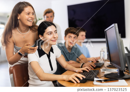 Cheerful friends playing online game together at computer club 137023525